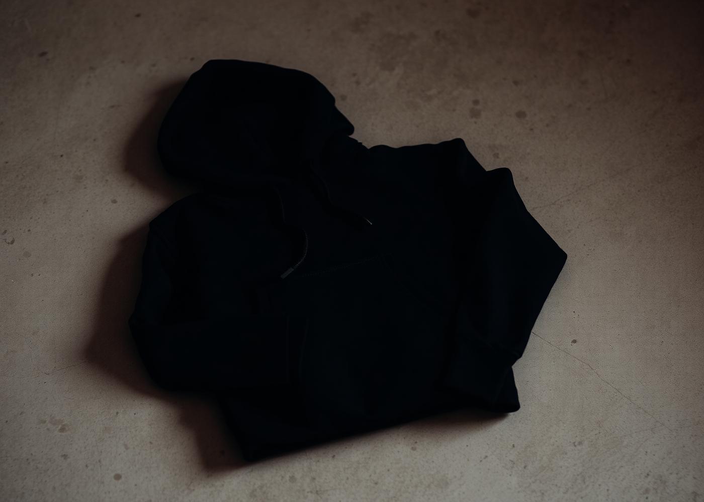 A minimal dark hoodie folded on a linen surface